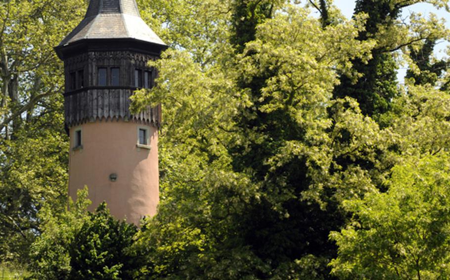 A tower peaks over the lush vegetation of the island of Mainau. The island is home to thousands of varieties of flowers, trees and exotic plants.