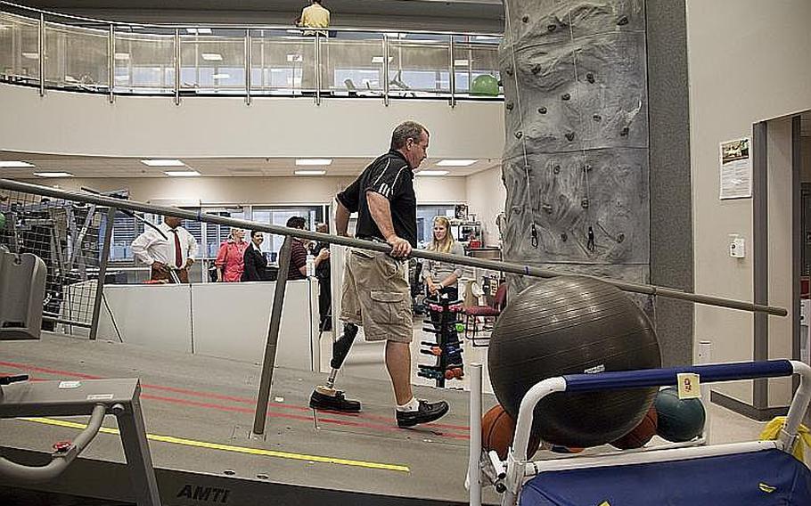 Vietnam veteran John Loosen, who lost a leg in Vietnam, shows off a new microprocessor-controlled prosthetic knee during a photo opportunity with his physical therapist Lindsay Martin, right, Wednesday, Aug.. 18,, 2010, at Walter Reed Army Medical Center in Washington. Loosen is the first Vietnam Veteran to get this new technology in prosthetics. 