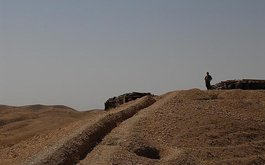 A Peshmerga soldier stands at an outpost at Checkpoint 3 in the Combined Security Area, where one Kurdish and one Iraqi soldier simultaneously stand watch over desolate lands outside of Khanaqin, a Kurdish town near the Iranian border. Each man has his own small shelter. On a recent day, the two soldiers at the top of the hill did not speak the other's language. They worked together for four hours in silence.