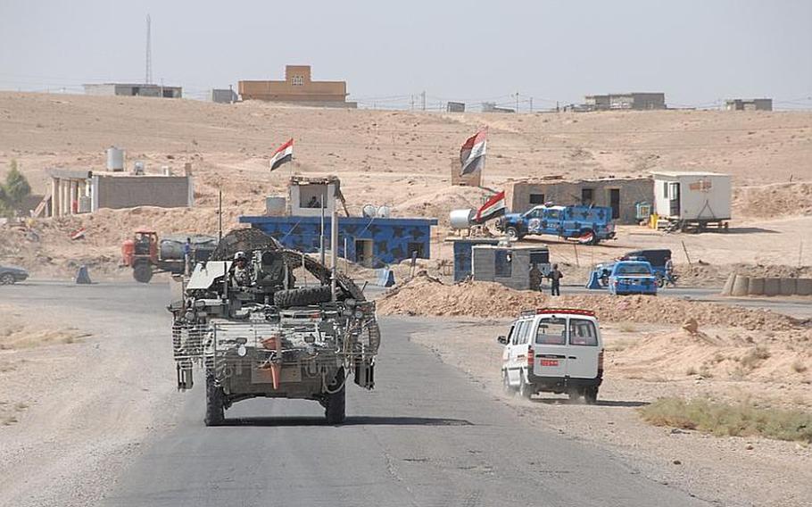 Outside the Combined Security Area, Iraqi forces man unilateral checkpoints, like this one run by Iraqi police. U.S. soldiers with the 2nd Squadron, 14th Cavalry Regiment, part of the 2nd Stryker Brigade Combat Team, 25th Infantry Division, drive past the police on their way to a trilateral checkpoint deeper in Diyala's Hamrin region, rural hills dotted with towns of Kurds and Arabs living together near the Iranian border.