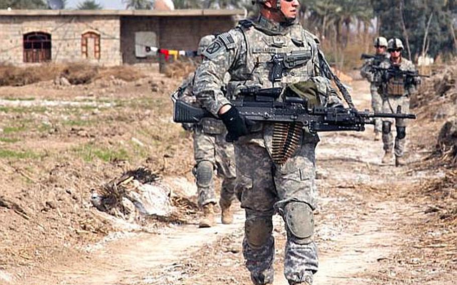 U.S. Army Pfc. Justin Gallager, assigned to Alpha Company, 1st Battalion, 38th Infantry Regiment, 4th Brigade, 2nd Infantry Division, carries an M240B machine gun on a patrol near Baghdad, Iraq, on Feb. 11, 2010.