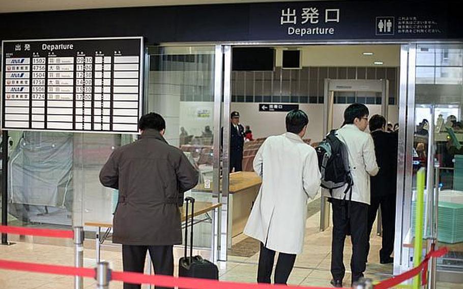 People begin to go through security in preparation to board the first flight to depart Sendai Airport in Sendai, Japan, since the March 11 tsunami ravaged the airport and region.