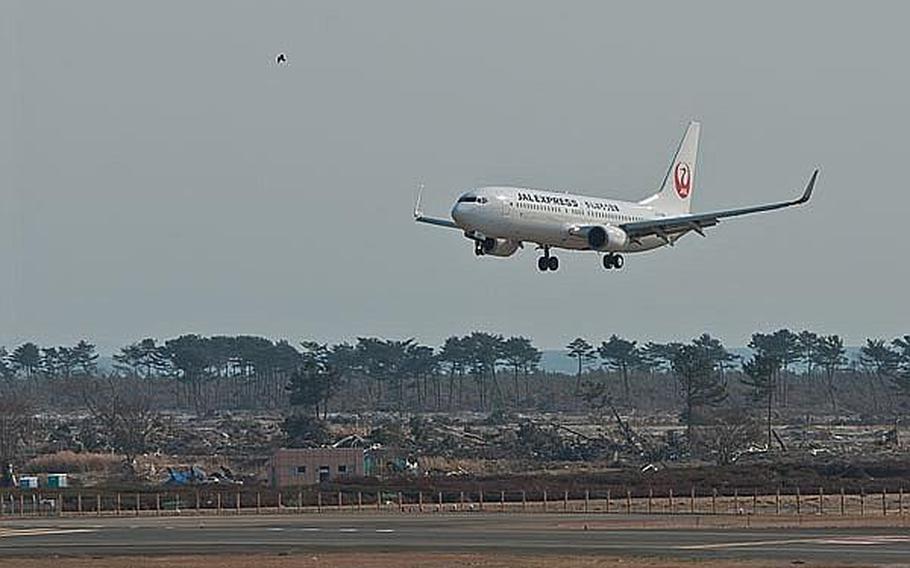 A Japan Airlines Express flight from Haneda Airport lands at Sendai Airport in Sendai, Japan, making it the first commercial flight to the airport since the March 11 tsunami ravaged the airport and region. The message, 'Let's get through this, Japan' was written on the side of the Boeing 737.
