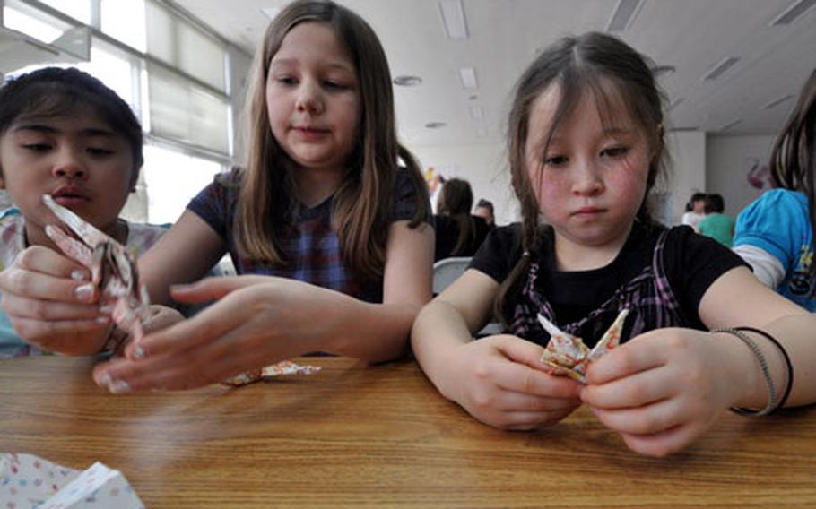 Third-graders from Sollars Elementary School at Misawa Air Base, Japan, work together April 8 to build origami cranes. Each crane they folded earned a $2 donation by the Bezos Family Foundation.