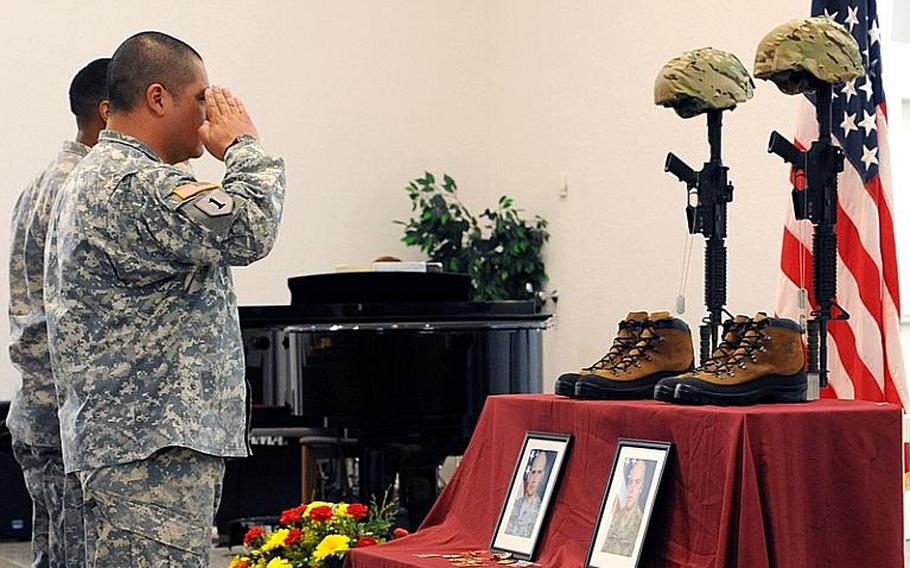 Two soldiers give a final salute to Staff Sergeants Scott Burgess and Michael Lammerts following a memorial ceremony in Baumholder, Germany. The 1st Battalion, 84th Field Artillery Regiment, 170th Infantry Brigade Combat Team soldiers were killed in Afghanistan on April 4.