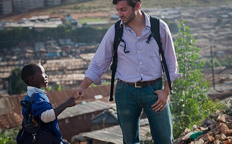 A young resident of Kibera, in Nairobi, shares a "gota" fist-bump with Rye Barcott, a Marine veteran who cofounded a nongovernmental organization designed to help its residents.