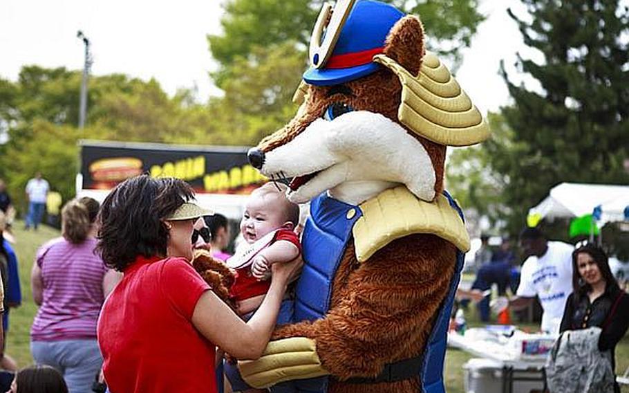The 374th Force Support Squadron&#39;s mascot, &#39;Samurai Fox,&#39; greets a young concert attendee of &#39;Tomodachi Stock&#39; Saturday at the Sakura Shell on Yokota Air Base, the site of a free concert to raise money through concessions and Red Cross donations for the tsunami victims in northern Japan.