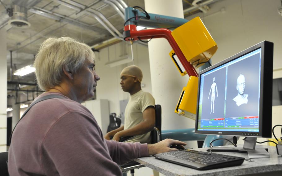 Brian Corner, a scientist at the Natick Soldier Research, Development and Engineering Center in Massachusetts, measures a soldier&#39;s head and face using a 3-D scanner.
