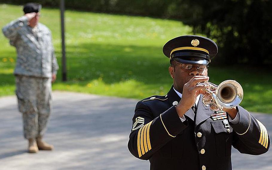 Staff Sgt. Joel Trammel salutes as Sgt. 1st Class Brandon Madison of the U.S. Army Europe Band plays taps at the conclusion of the memorial ceremony Wednesday for Staff Sgt. Jose M. Caraballo Pietri, in Baumholder, Germany.