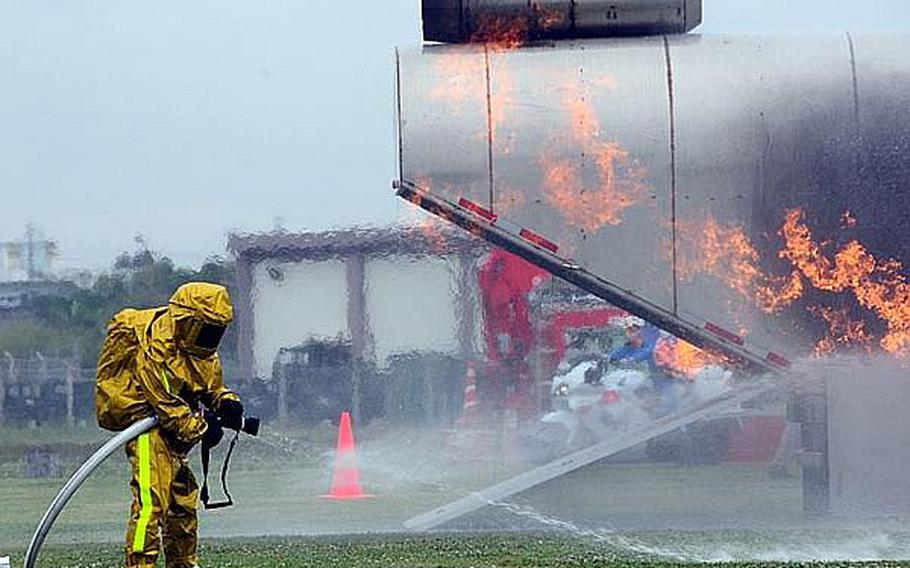 A firefighter readies his hose in preparation for dousing a simulated helicopter fire  during an annual bilateral training exercise between the U.S. military and Japanese Emergency Response Teams. This is the sixth year of the exercise with each year getting more elaborate as more elements are added.