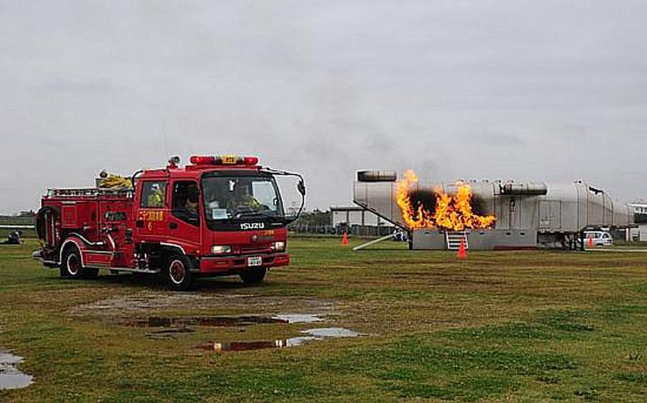 A Japanese fire truck pulls up alongside a simulated aircraft crash during Wednesday&#39;s annual bilateral training exercise between Japanese Emergency Response Teams and the U.S. military. This is the sixth year of the exercise, which is designed to improve and reinforce emergency response procedures.