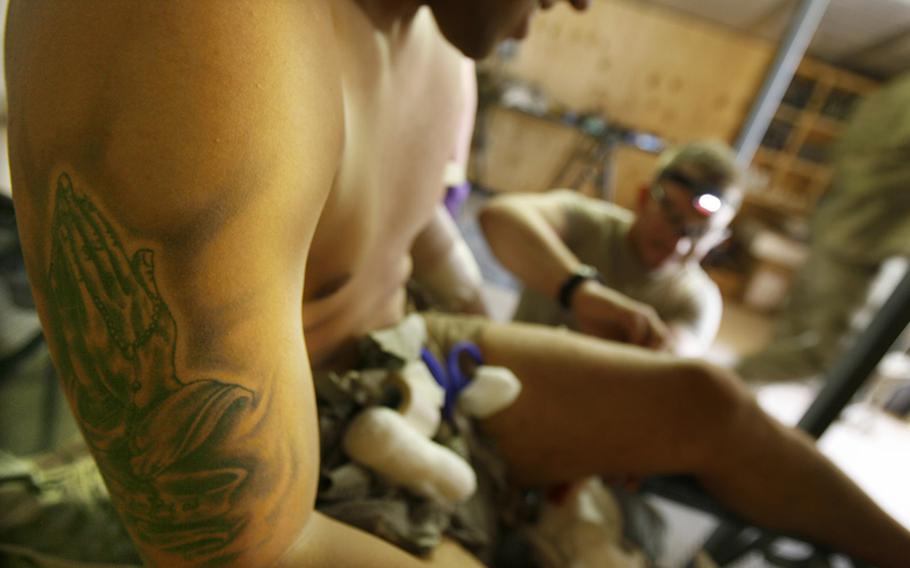 Spc. Victor Bardales is treated for shrapnel wounds by medics Sgt. Joe Tapia, left, Sgt. Miles Boggs and Pfc. Nicholas Seay from an rocket-propelled grenade attack Saturday near Combat Outpost Nalgham, Afghanistan.