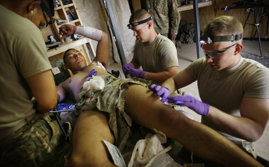 Spc. Victor Bardales is treated for shrapnel wounds by medics Sgt. Joe Tapia, left, Sgt. Miles Boggs and Pfc. Nicholas Seay from an rocket-propelled grenade attack Saturday near Combat OutPost Nalgham, Afghanistan.