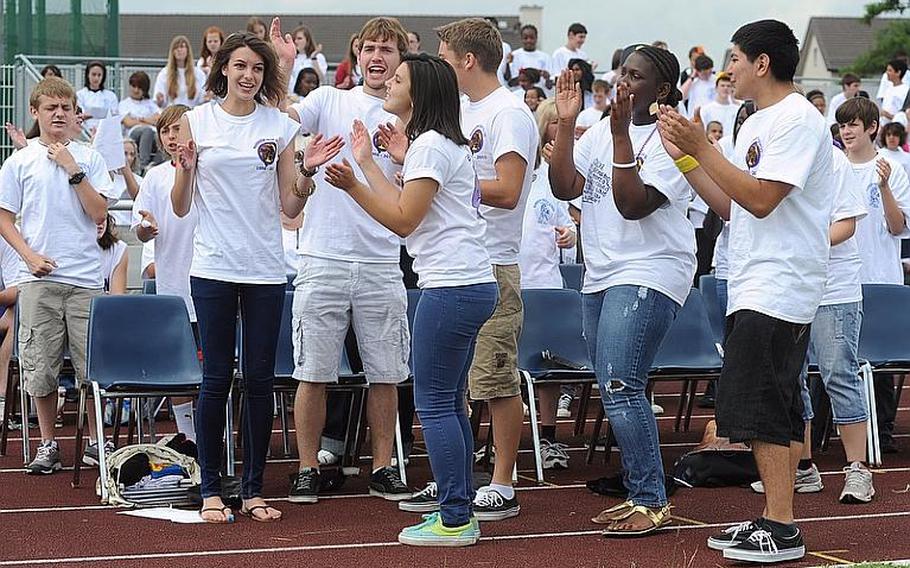 Members of the Mannheim High School drama club dance and sing "Time of My Life" at the "Moving On" celebration on Woods Memorial Field on Thursday. The ceremony marked the closing of Mannheim High after 55 years and the closing of the middle school after 36 years. In the background are middle school students.