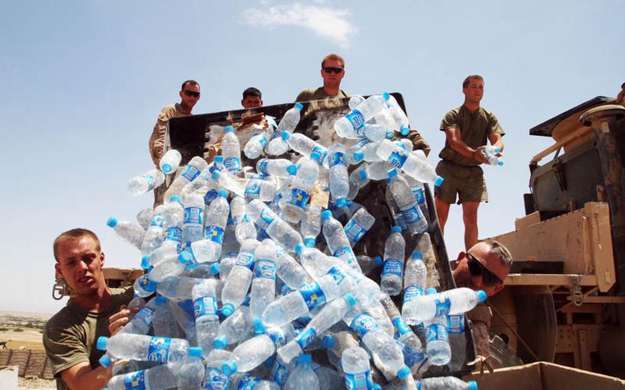 Marines with Company K, 3rd Battalion, 2nd Marine Regiment, offload bottled water from a truck in late May at Observation Post Padlek near the southern tip of Musa Qala district, Helmand province.