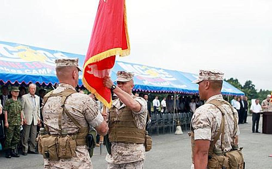 Col. Anthony Johnson receives the unit guidon from outgoing commander Col. Craig Kozeniesky during the change-of-command ceremony for the Combined Arms Training Center at Camp Fuji, Thursday.