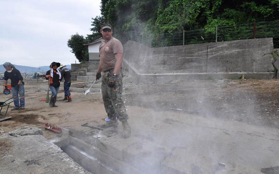 Petty Officer 1st Class Joshua Thonnissen tosses a powder meant to help kill bacteria into a drainage ditch in Miyako, Japan, on Thursday. Thonnissen is one of three U.S. Navy Seabees currently working to help Japanese residents recover from a deadly tsunami that raced through the coastal city on March 11, following the massive earthquake that rattled the island nation.