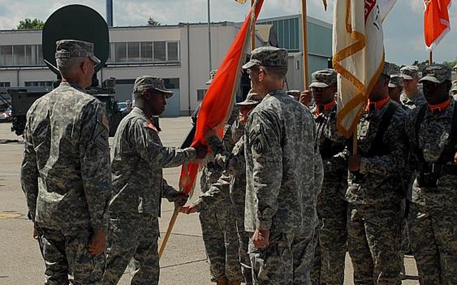 Col. Bruce T. Crawford hands the 5th Signal Command's colors to 5th Signal's top enlisted noncommissioned officer, Command Sgt. Maj. Marilyn Washington.