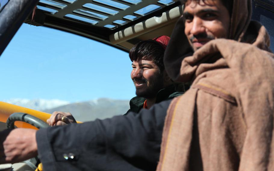 An Afghan worker and his helper use a forklift to download materials from a truck at Combat Outpost Garda, Afghanistan, in 2009. Getting materials to COP Garda via the highway can be a dangerous business. Trucks can become targets during road-clearing operations.
