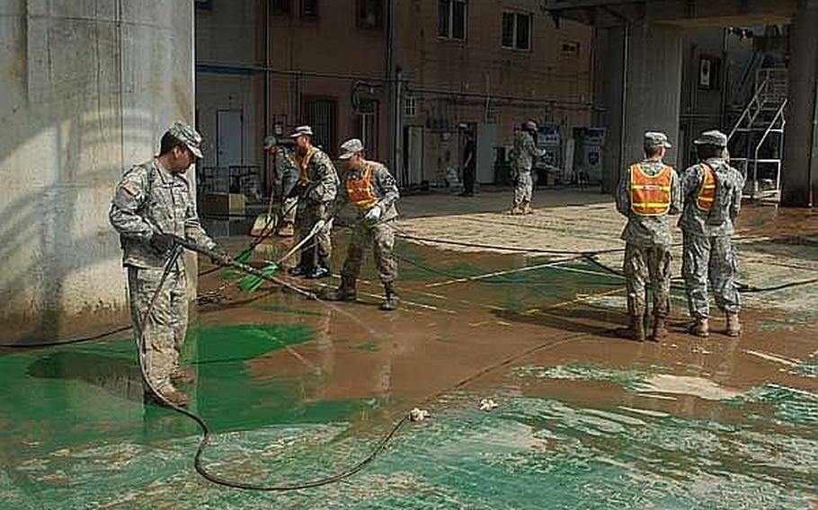 Soldiers from the 2nd Infantry Division on Friday help clean up The Ville, an entertainment district across from Camp Casey in South Korea that was flooded this week after heavy rains pounded the peninsula.