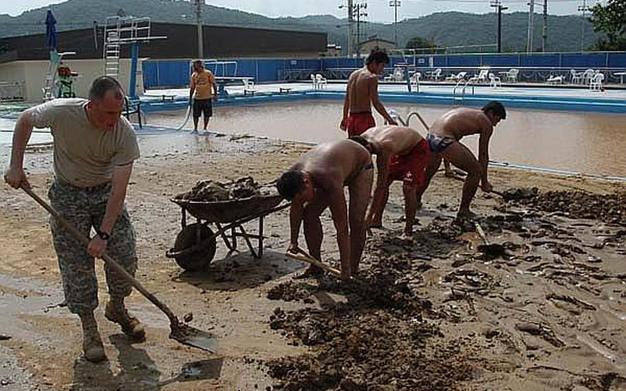 Soldiers and staff shovel up mud left by a landslide in and around the pool at Hanson Fieldhouse at Camp Casey, South Korea. Three days of heavy rains this week were blamed for dozens of deaths across the peninsula, and caused extensive damage at three U.S. military bases in Dongducheon.