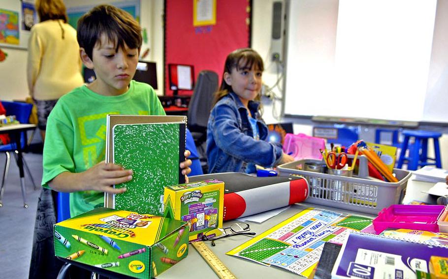 Conner Mackie, 9, organizes his school supplies on the first day of the new school year Monday in Laura Rahaim&#39;s fourth-grade class at Vogelweh Elementary School in Kaiserslautern, Germany.