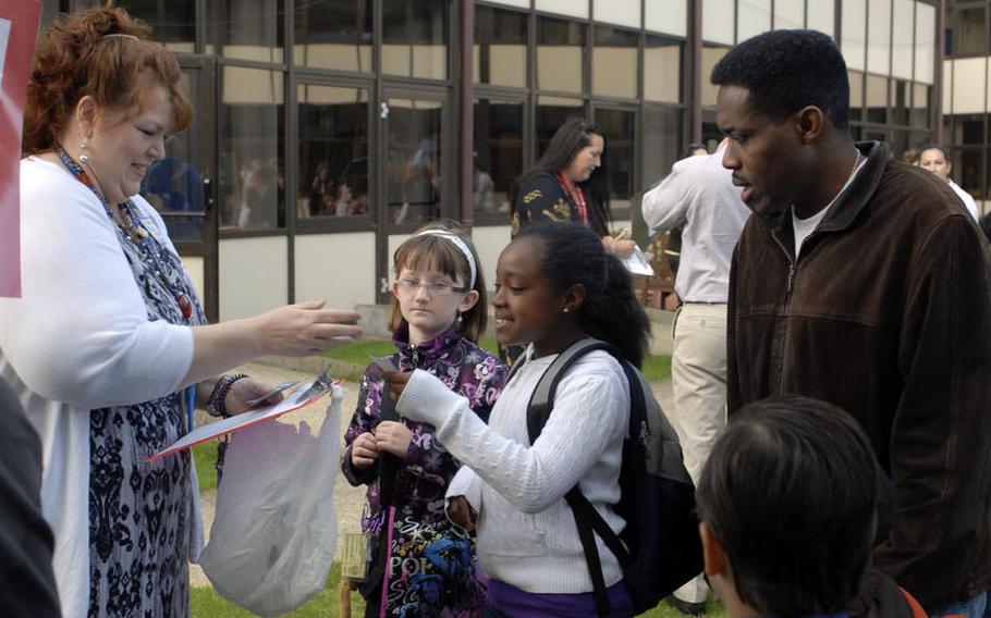 Third grade teacher Debbie Hand introduces herself to her newest student, Jasmine Jordan, and her father Darrel outside RAF Lakenheath Elementary School, Aug. 29. The first day of the new school year saw hundreds of families meeting with teachers and school officials. Jordan, who hails from Tifton, Ga., escorted three daughters to school at the eastern England air base.