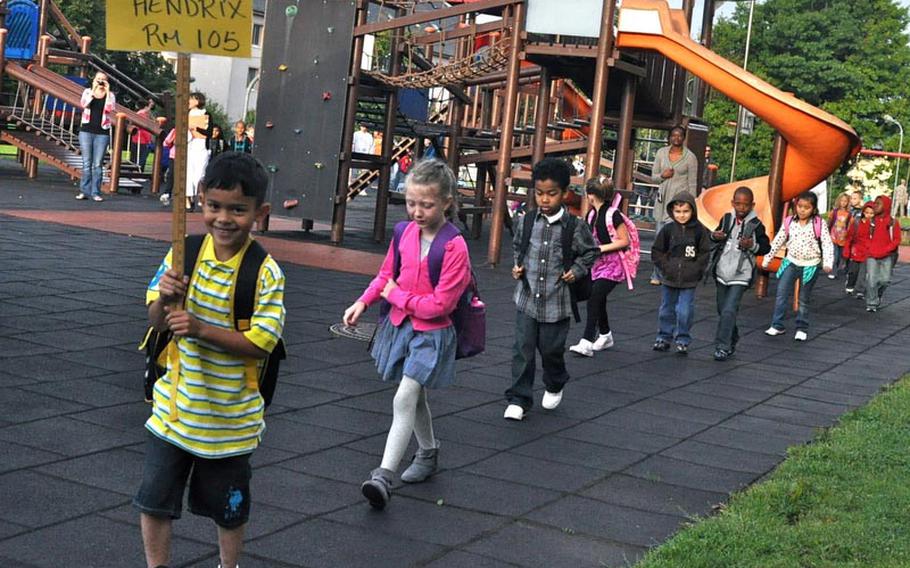 First-grader Elezar Martinez leads his classmates into Smith Elementary School Monday at U.S. Army Garrison Baumholder in Germany. It was the first day of school for pupils at Department of Defense Dependents Schools-Europe.