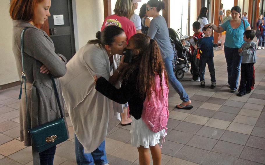 Cheryl Buggs embraces her daughter, Victoria, 7, after Victoria's first day in the second grade at Grafenwoehr Elementary School. The school enrolled roughly 300 children for the school year, principal Crystal Bailey said.