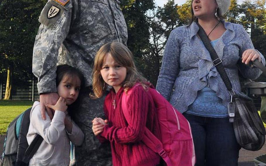 Spc. Benjamin Shirley and his wife, Cassie, help their 6-year-old daughter Jozlyn search for her teacher at Smith Elementary School on U.S. Army Garrison Baumholder in Germany. Jozlyn (right) started 1st grade on Monday, and her sister Rochelle (left) came to see her off. Rochelle, 5, is to start kindergarten next week.