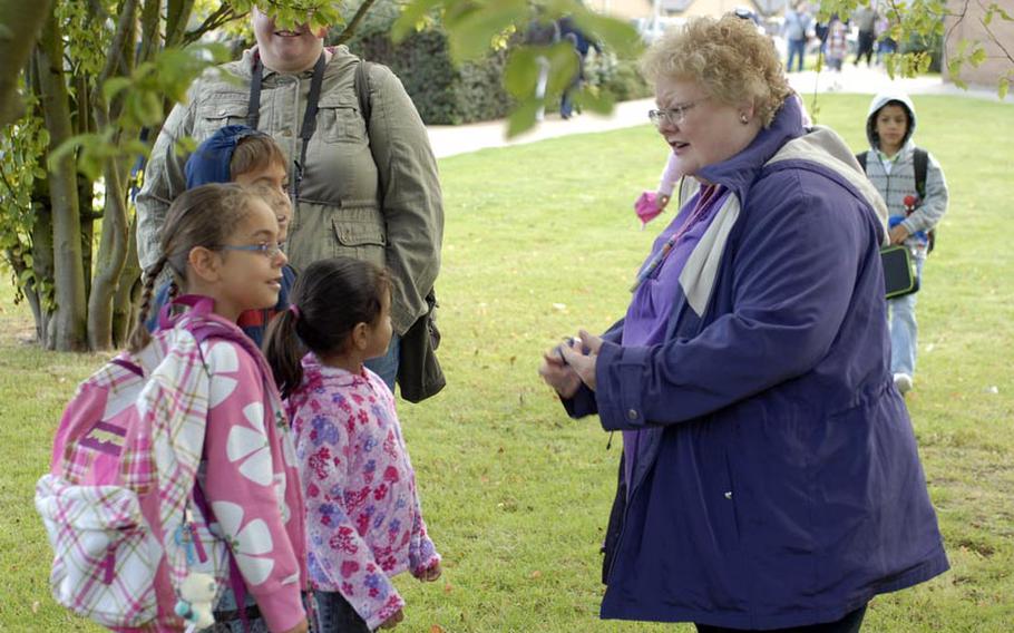 Leslie Sacchi, a kindergarten teacher at RAF Lakenheath Elementary School, welcomes three young children to the first day of the new school year. Sacchi, a native of Ukiah, Calif., has taught at RAF Lakenheath schools for the past 17 years.