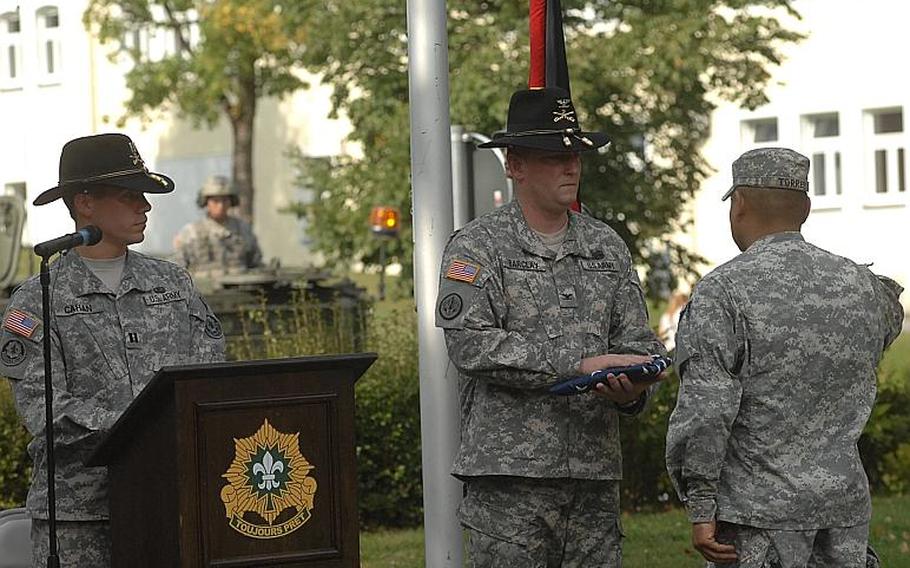 During a Sunday ceremony at Rose Barracks in Vilseck, Col. Keith Barclay, commanding officer of the 2nd Stryker Cavalry Regiment, accepts an American flag that accompanied a steel I-beam from the World Trade Center. The artifact was to be transported to nearby Oberviechtach for a German 9/11 memorial.