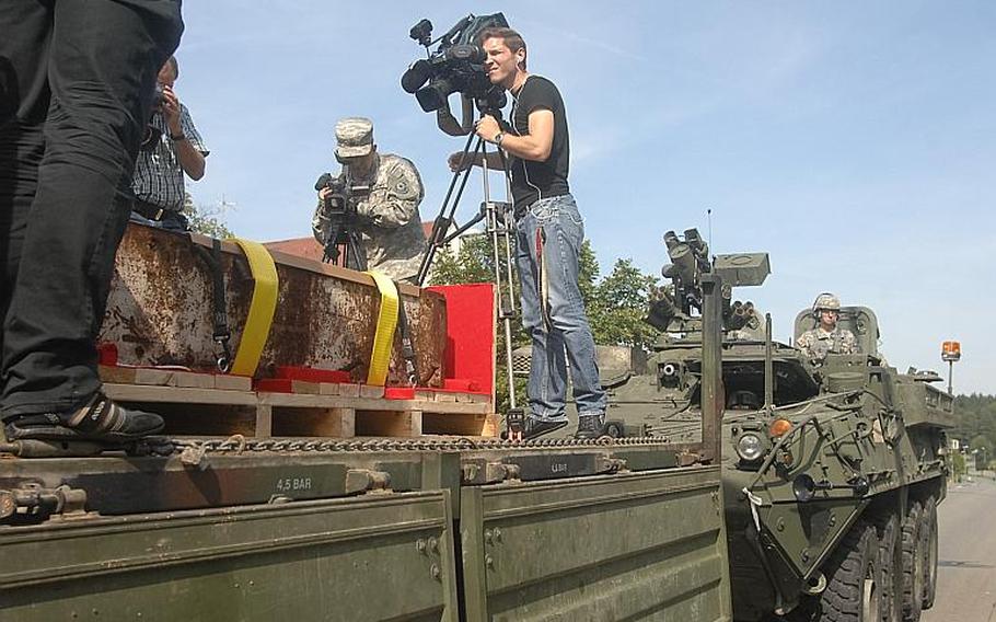 German and Army media gather around a steel beam from the World Trade Center, brought to Germany for an intended memorial in the nearby town of Oberviechtach.