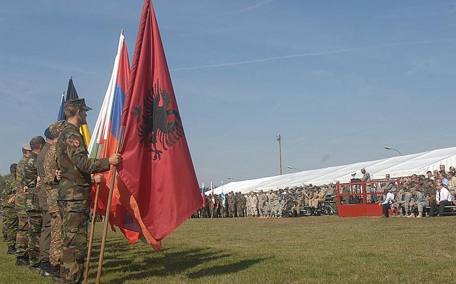 Soldiers from 18 countries that lost citizens in the 9/11 attacks on the World Trade Center and the Pentagon hold the flags of their respective nations during a European Command ceremony on Sunday at the Grafenwoehr Training Area. EUCOM is holding a multinational training exercise, Combined Endeavor, at one of the training area's camps.