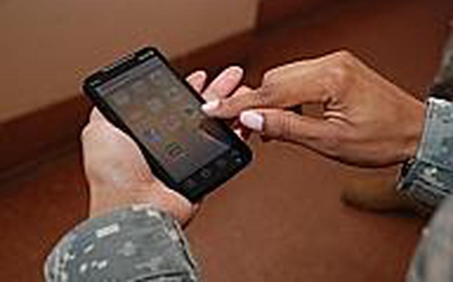 Capt. Tennille Scott of the Army's Mobile Applications Branch holds an Android phone, preparing to start one of dozens of ''military lifestyle'' apps the group has published for both Android and Apple devices.