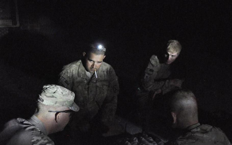 A combat engineer reviews an APOBS (Anti-Personnel Obstacle Breaching System) device with soldiers before a night mission in southern Kandahar. Launched by a small rocket, the APOBS lays out a line of explosives, allowing engineers to clear areas where IEDs or mines may be hidden.