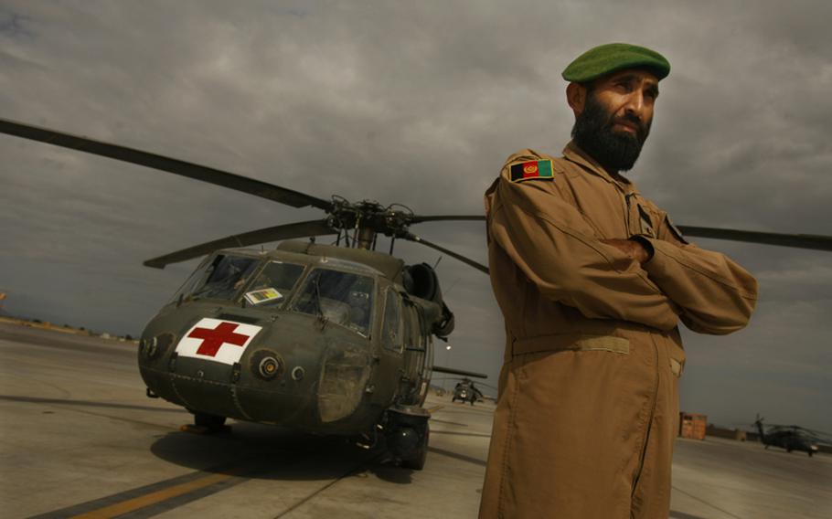 Afghan air force flight medic Sgt. Gulap Ahmadzia pauses near a U.S. medevac helicopter at Mustang Ramp on Oct. 11 at Kandahar Airfield. Soldiers with Company C, 1st Battalion, 52nd Aviation Regiment are training and mentoring the Afghan medics.