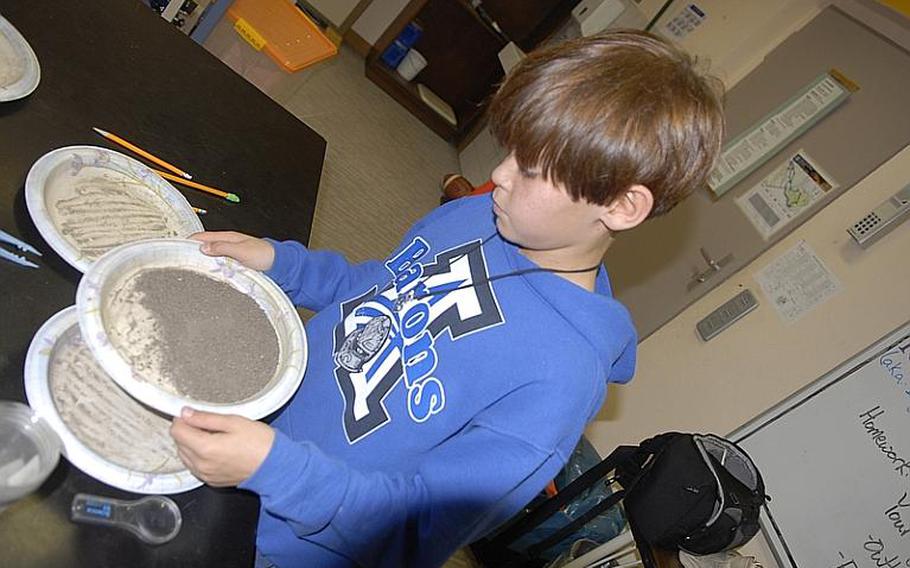 Noah Bolneo, 11, sifts through dirt in teacher Tom Oliver's science class at Bitburg Middle School. Oliver's fifth and sixth graders are participating in the Mastodon Matrix Project, helping researchers in the states examine sediment unearthed from a mastodon evacuation site in New York. The project is part of an effort by Defense Department schools to encourage student interest and learning in science and math.