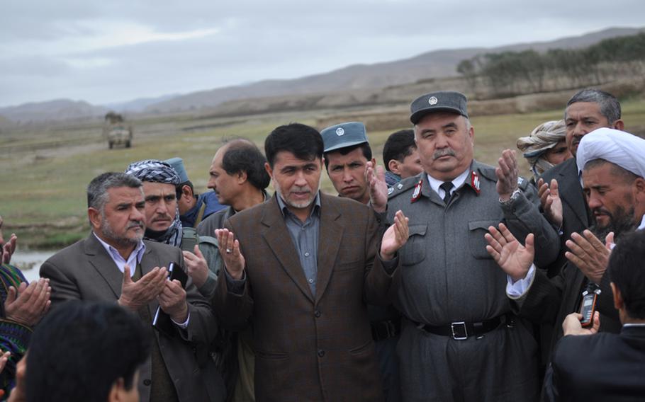 Abdul haq Shafaq, center, governor of Faryab province, offers prayers after a ceremony opening a new river crossing near the village of Gormach in western Faryab Province.