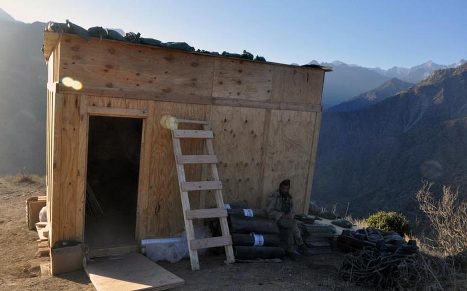 An Afghan Border Patrol officer rests outside an observation point that U.S. soldiers built for the Afghan military last month in Kunar province. The outpost stands midway between Observation Point Mace, which sits at almost 6,000 feet above sea level, and Observation Fowlad a mile below.