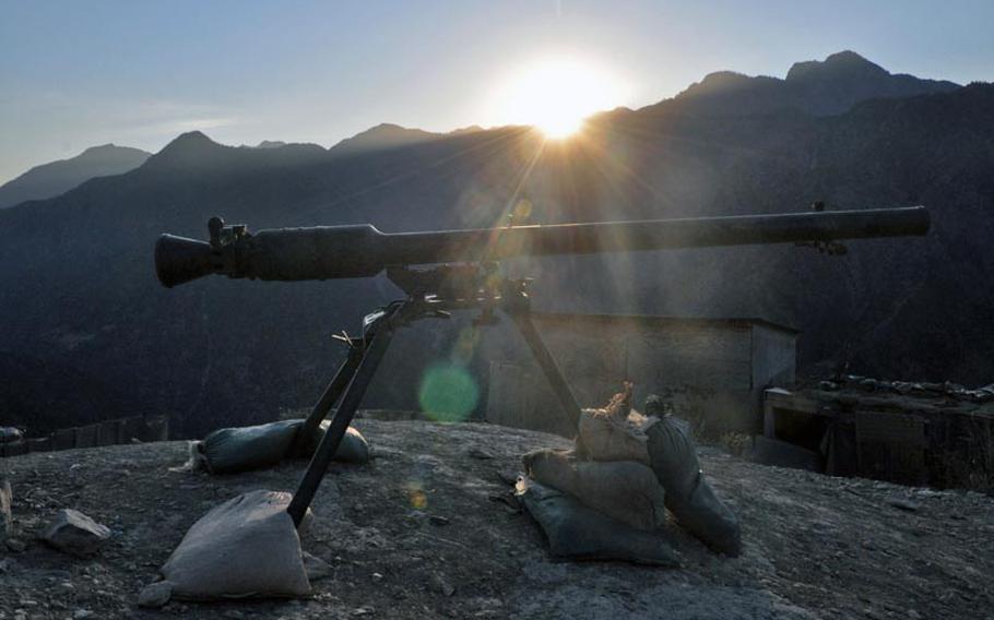 A recoilless rifle stands ready at Observation Point Mace, an outpost occupied by the Afghan army in Kunar province, as the sun sets behind the Hindu Kush mountains.