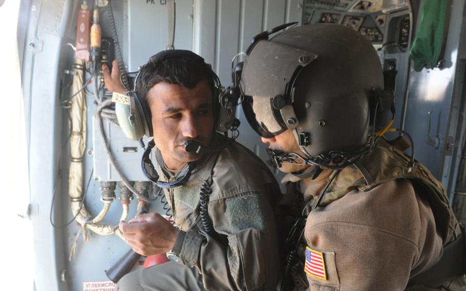 Afghan Air Force recruit Abdul Razeq, left, talks with U.S. Air Force Staff Sgt. Christopher Morford during a training flight near Shindand Air Base in Herat province.