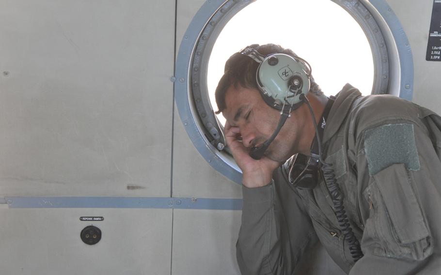 Abdul Razeq, training to become a helicopter crew chief with the Afghan Air Force, dozes briefly during a training flight near Shindand Air Base in Herat province.