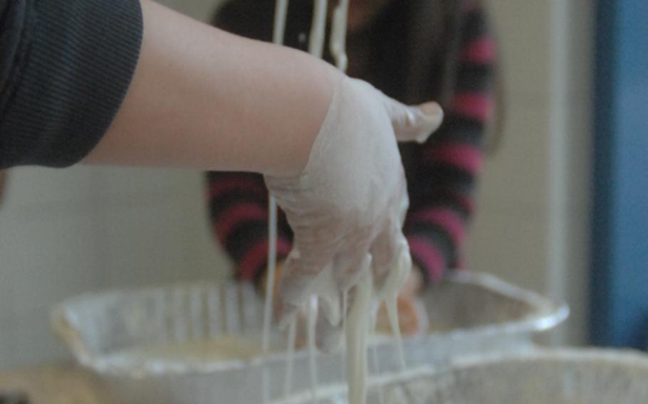 A cornstarch and water mixture drips off the hands of 9-year-old Gabriel Myers at the non-Newtonian liquid exhibit, part of Thursday's Math, Science, Technology Night at Hohenfels Middle/High School.