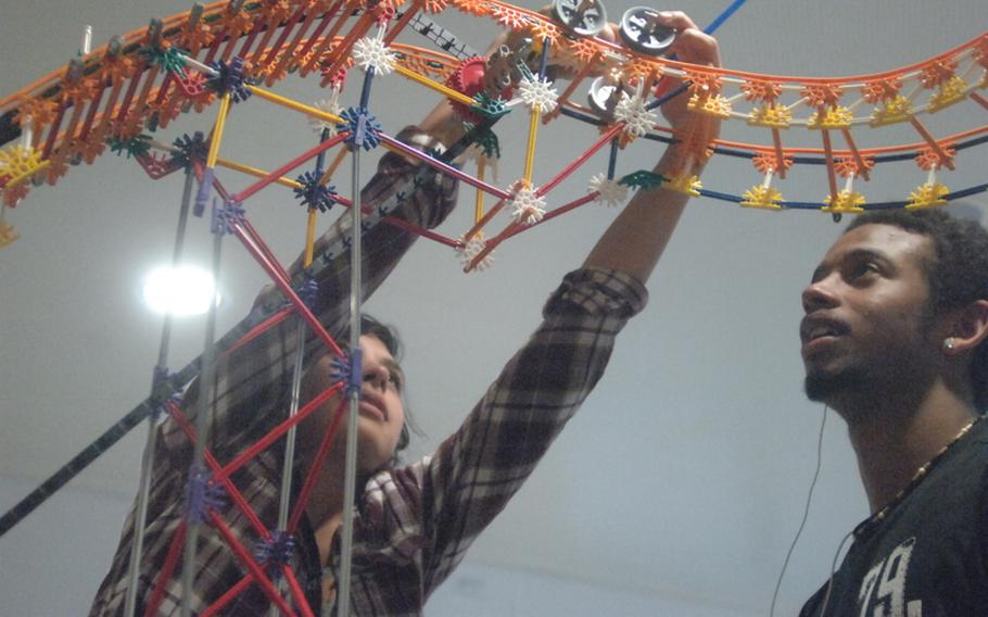 Alexis Perryman, 16, and Devon Fluker, 18, adjust a model car as part of the roller coaster exhibit at Thursday's Math, Science, Technology Night at Hohenfels Middle/High School.