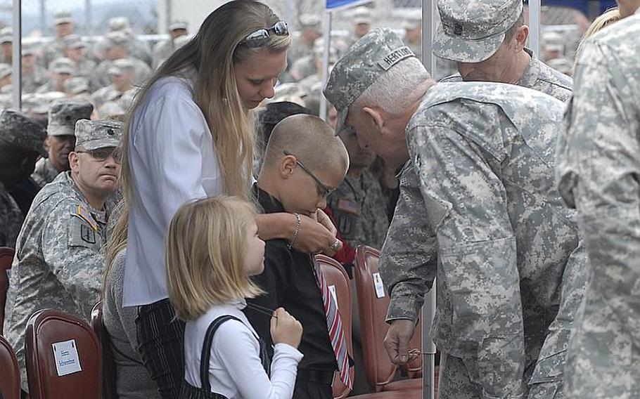 Lt. Gen. Mark P. Hertling, U.S. Army Europe commander, says a few words to Oliver Dixon, 8, and his family, mother Jana, and sister Brianna, 7, at a 170th Infantry Brigade memorial dedication Wednesday at Baumholder for the nine soldiers killed during the brigade's last deployment to Afghanistan. Oliver's father, Staff Sgt. Edward Dixon, died in a Humvee rollover last June.