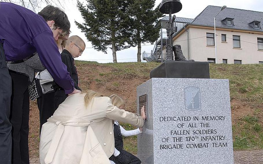 Jana Dixon, whose husband, Staff Sgt. Edward Dixon, died in Afghanistan last June, touches the names engraved on a memorial dedicated to the nine soldiers from the 170th Infantry Brigade Combat Team killed during the unit's last deployment to Afghanistan. With Jana Dixon was her daughter, Brianna, 7, and son, Oliver, 8, her mother Terry Haurisen, and a friend.