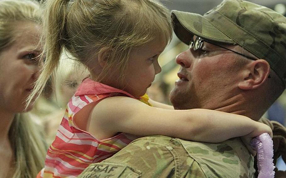 Spc. George Stonecipher takes a good look at his daughter, Marlee, 3, during a return ceremony Friday  for members of the 172nd Separate Infantry Brigade in Grafenwoehr, Germany. Several hundred soldiers returned to both Grafenwoehr and Schweinfurt, as the brigade ends a 12-month tour in Afghanistan.