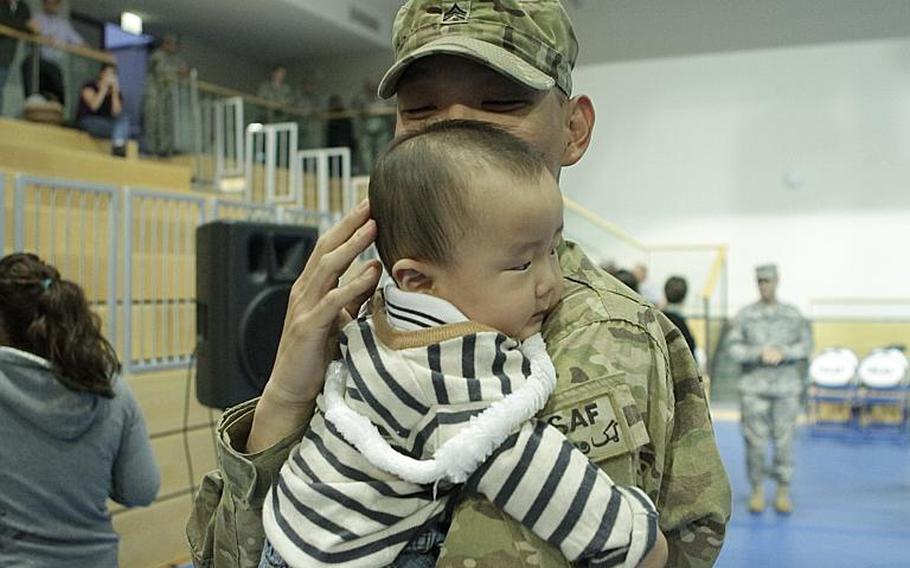 Sgt. Joon Park meets his 7-month-old son, Philip, during a Friday return ceremony for members of the 172nd Separate Infantry Brigade in Grafenwoehr, Germany. Several hundred soldiers returned to both Grafenwoehr and Schweinfurt, as the brigade gradually ends a 12-month tour in Afghanistan.