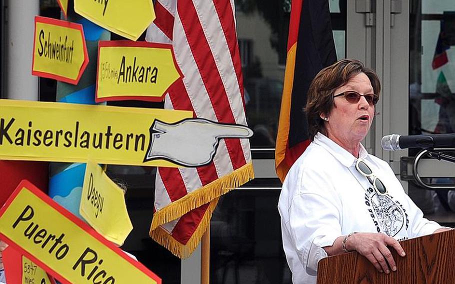 Mannheim Elementary School principal Sharon Overstreet speaks at the school&#39;s closing ceremony Friday in Mannheim, Germany. The school closed after serving the community, which itself is closing, for 66 years. The signs point to some of the places where the students will be attending school next year.